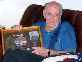 Andy Rasch, 107, with his service memorabilia.
